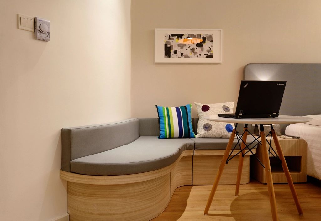 A guest room with a large bed and soft lighting